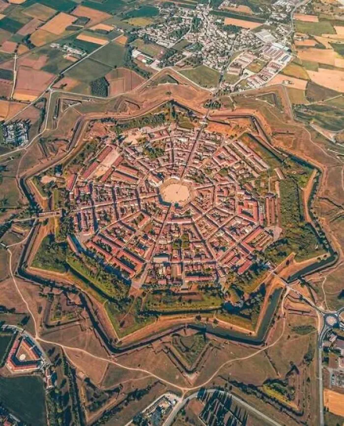 Aerial view of star-shaped historic fortress and town with surrounding landscape