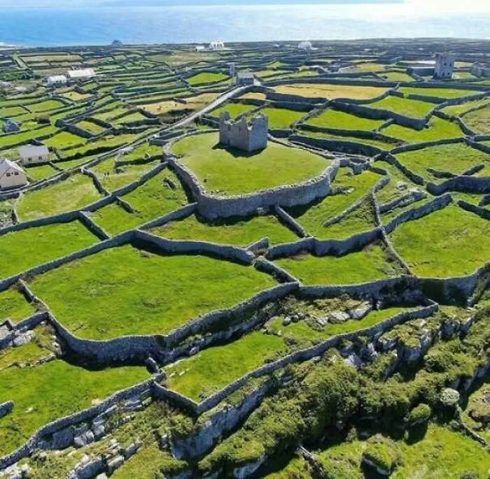 Ancient landscape of stone-walled farmland and historic ruins near sea