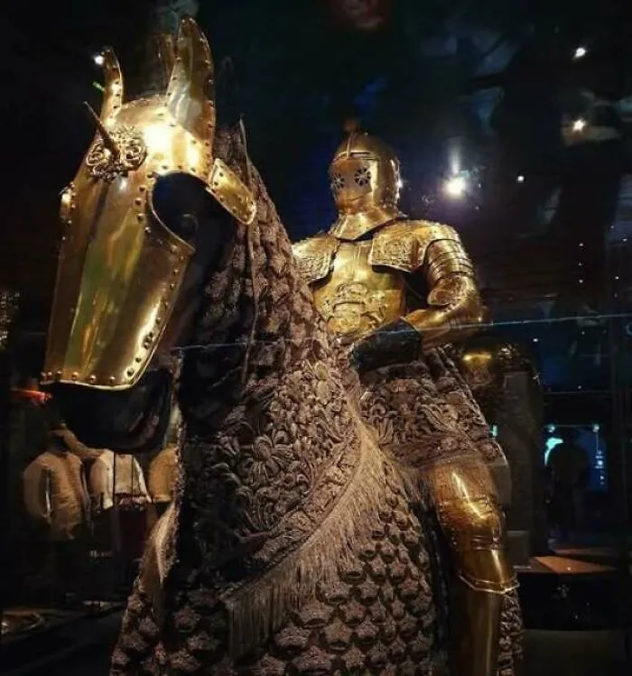 Impressive golden medieval knight armor on horseback with detailed decorations