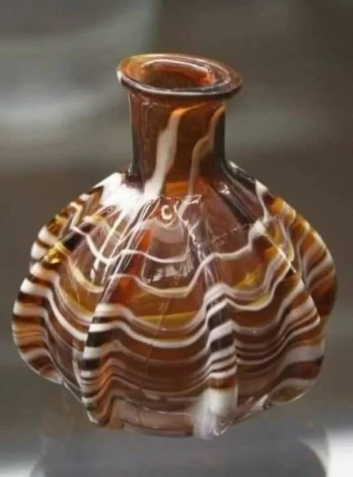 Ancient striped glass bottle with rounded base historical glassware