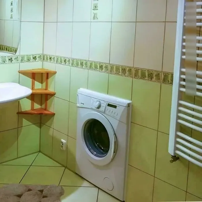 A washing machine built directly into a bathroom wall, demonstrating unusual Slavic engineering solution