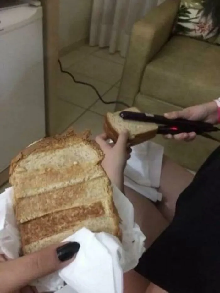 Person using a hair straightener to toast bread slices as a funny piece of Slavic engineering.