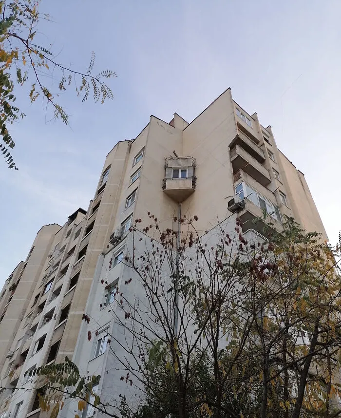An oddly attached floating balcony on a tall building, showcasing strange Slavic engineering.
