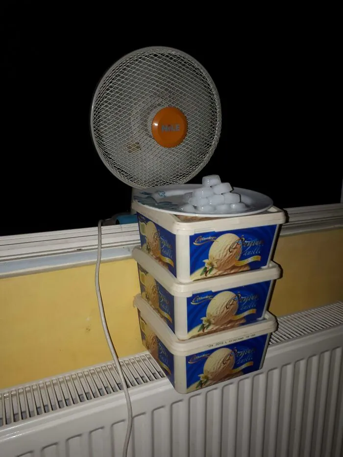 A makeshift air conditioner made with a desk fan and ice cubes, showing inventive Slavic engineering.