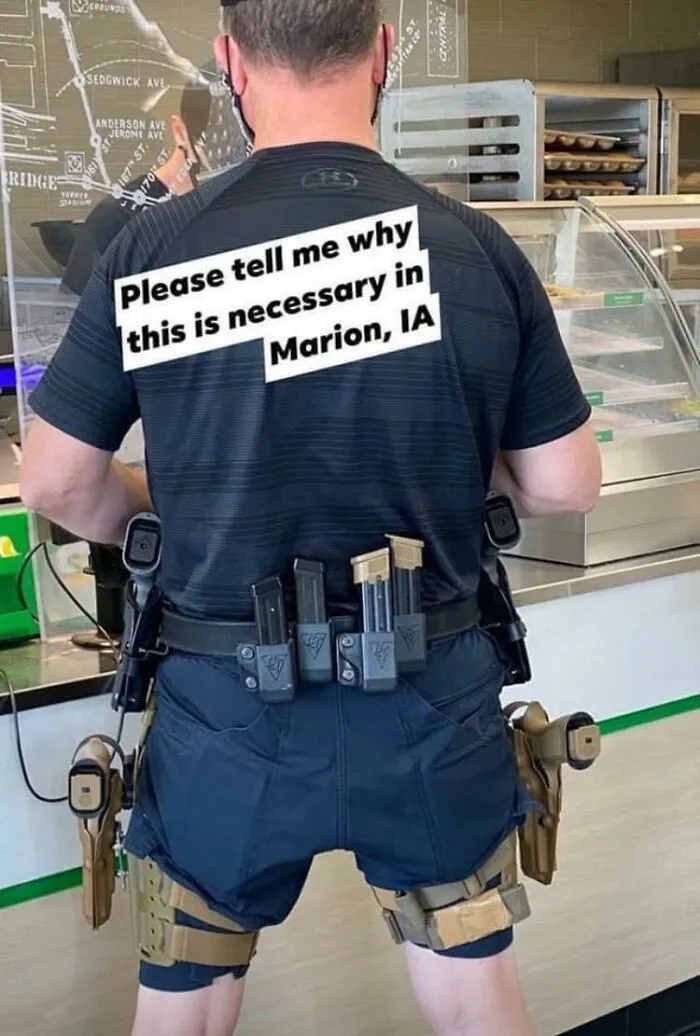 Person wearing tactical gear with many gun magazines and text questioning necessity in Marion, IA