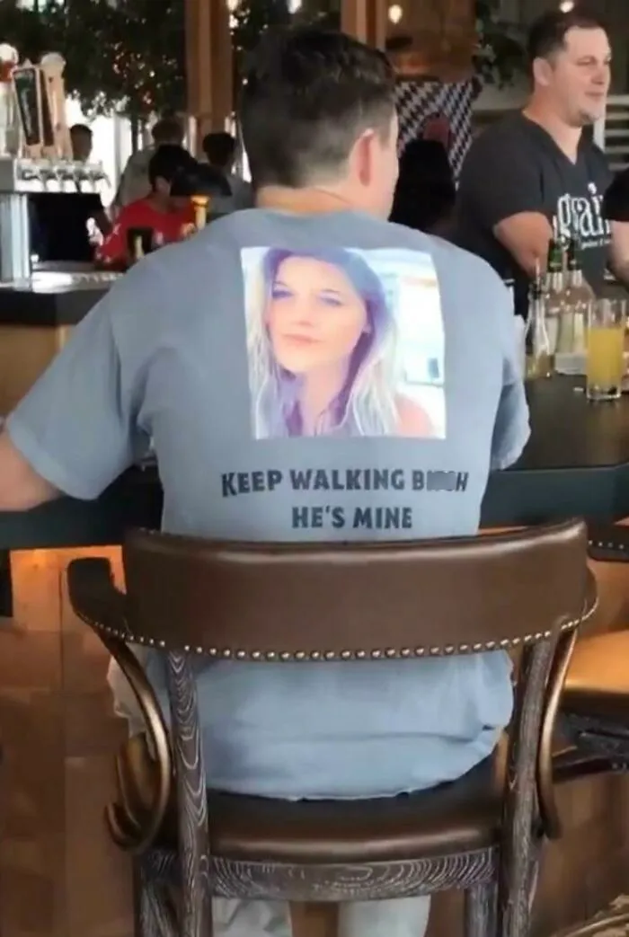 Man wearing a shirt with a photo and text claiming ownership in a tough online look fail