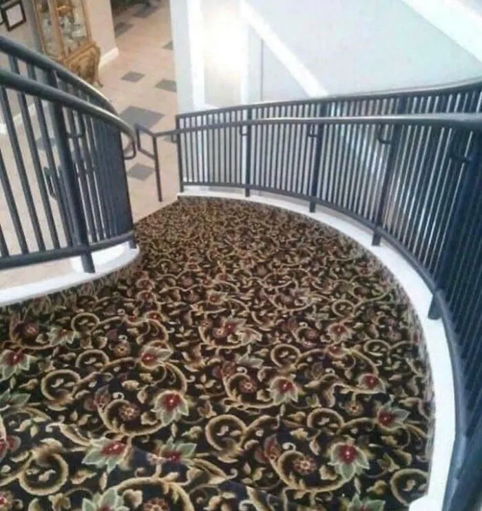 Curved staircase covered with floral patterned carpet