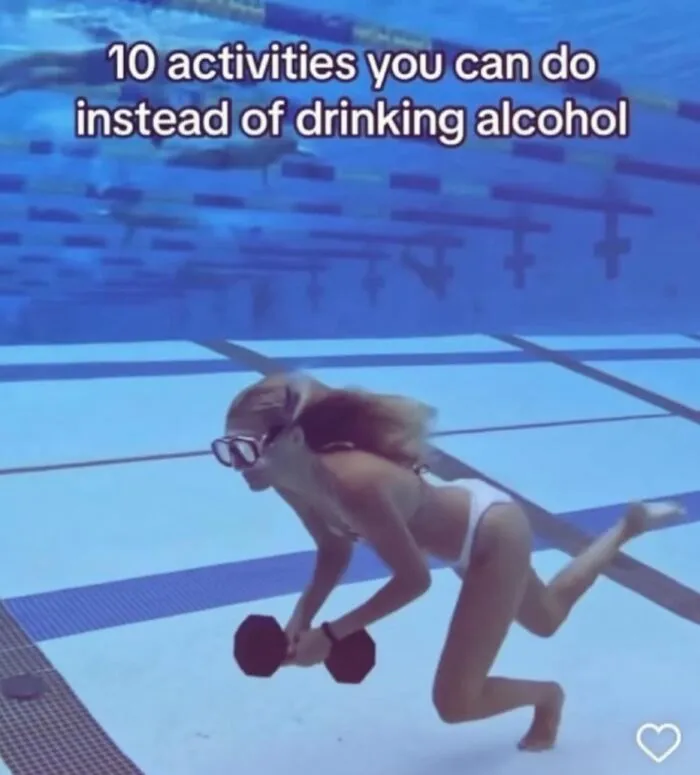 Woman lifting dumbbells underwater as alternative activity to drinking alcohol
