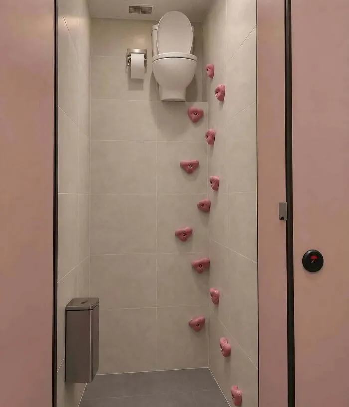 Hilarious pics of a toilet mounted at the top of a rock climbing wall inside a stall.