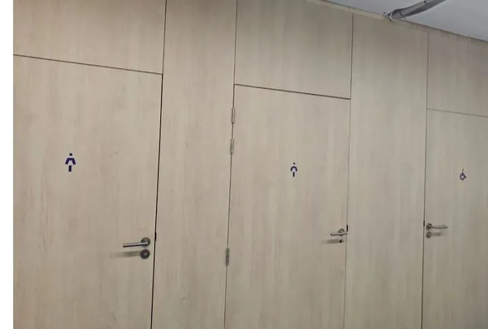 Bathroom doors with unclear and inconsistent signage for gender and accessibility