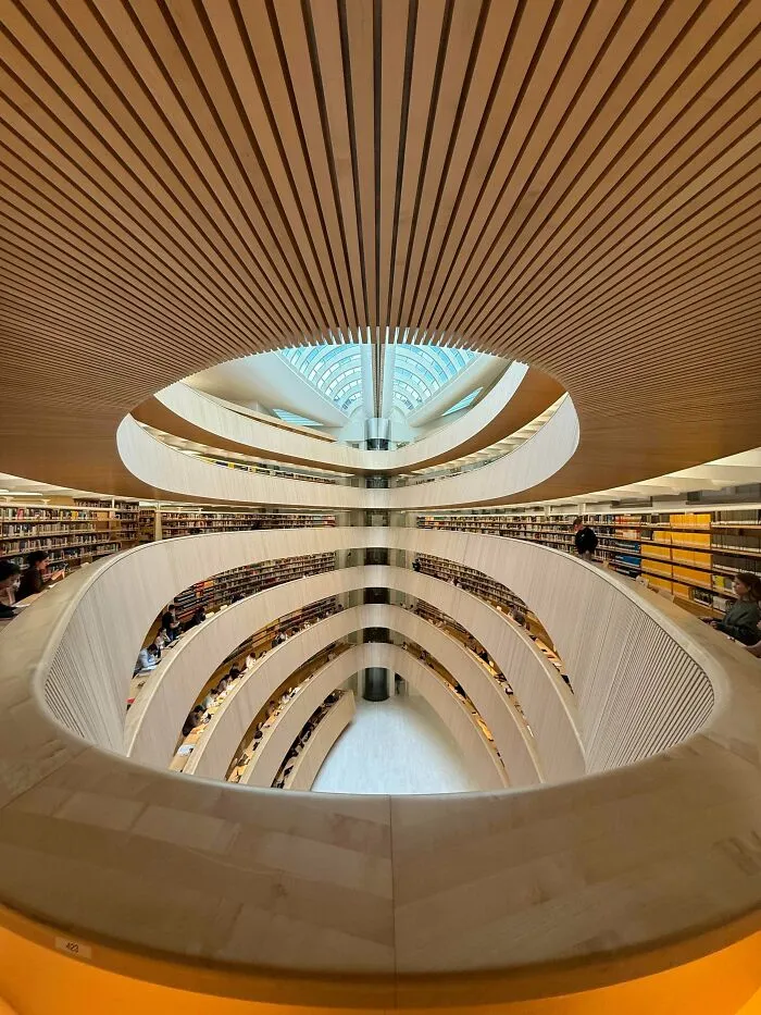Interior view of multi-level modern library, an architectural masterpiece with circular wooden balconies