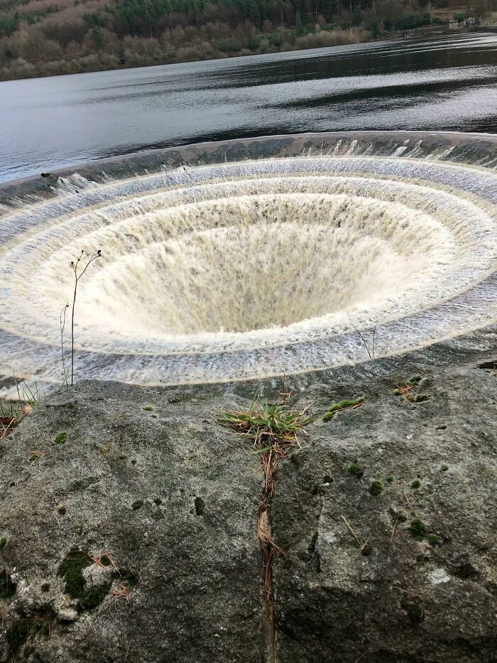 Circular deep water vortex or whirlpool funneling water in nature