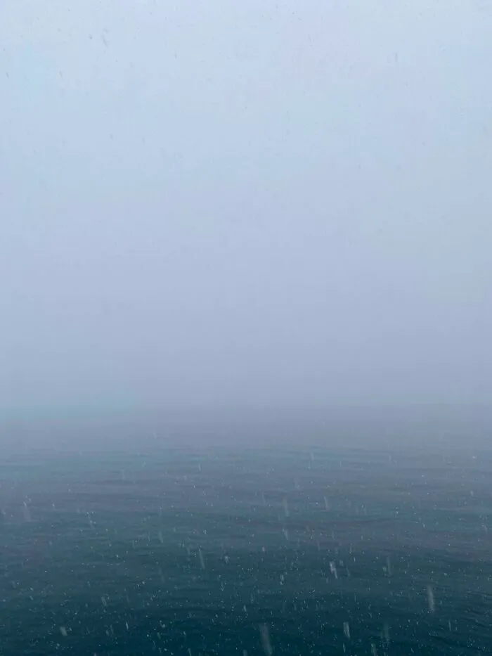 Foggy deep-water sea with low visibility and falling rain