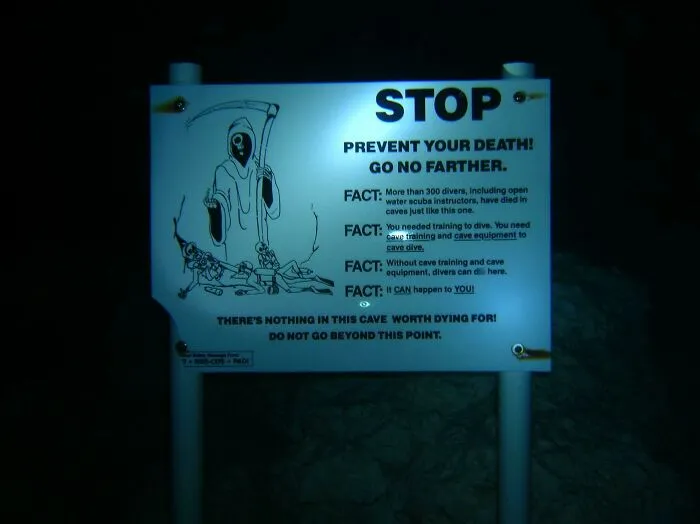 Warning sign underwater cautioning divers about cave dangers
