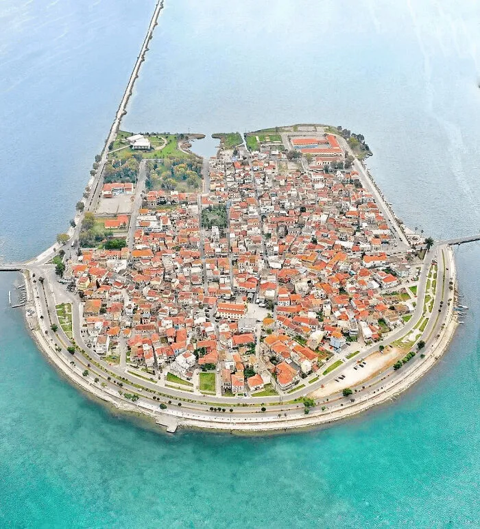 Aerial view of coastal town surrounded by blue ocean water