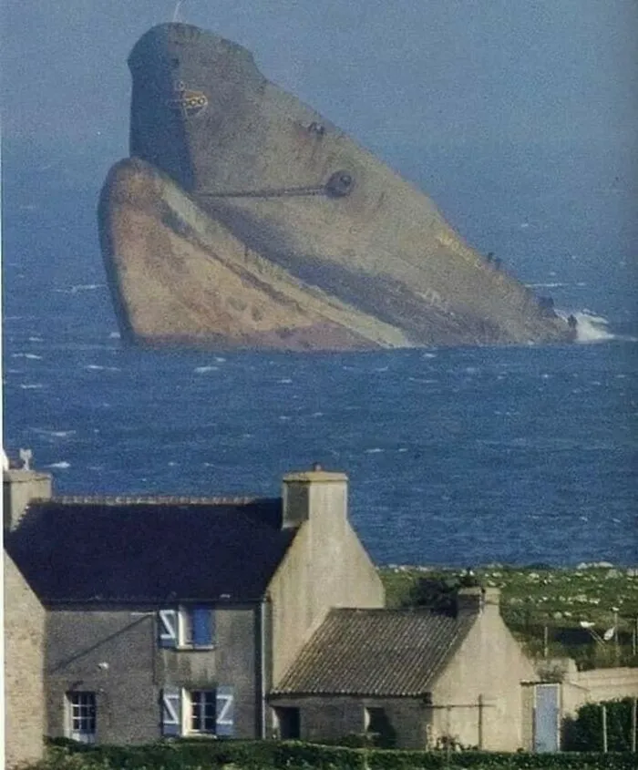 Creepy deep-water photo of a shipwreck resembling a submerged face near houses