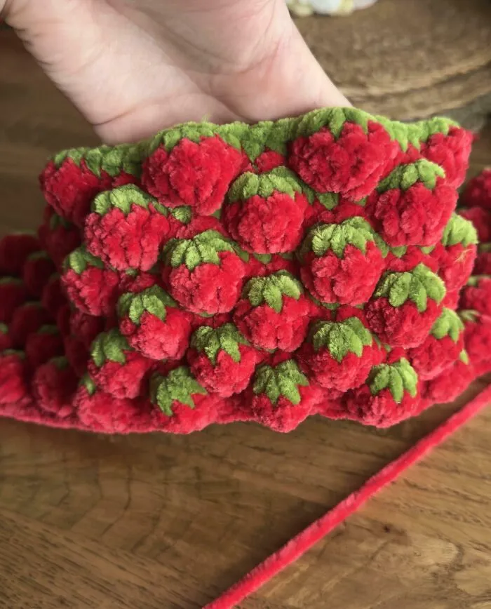Close-up of red and green crochet piece resembling strawberries
