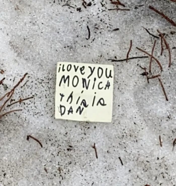 A small note in the snow reading I love you Monica this is Dan, showcasing lost and forgotten messages.