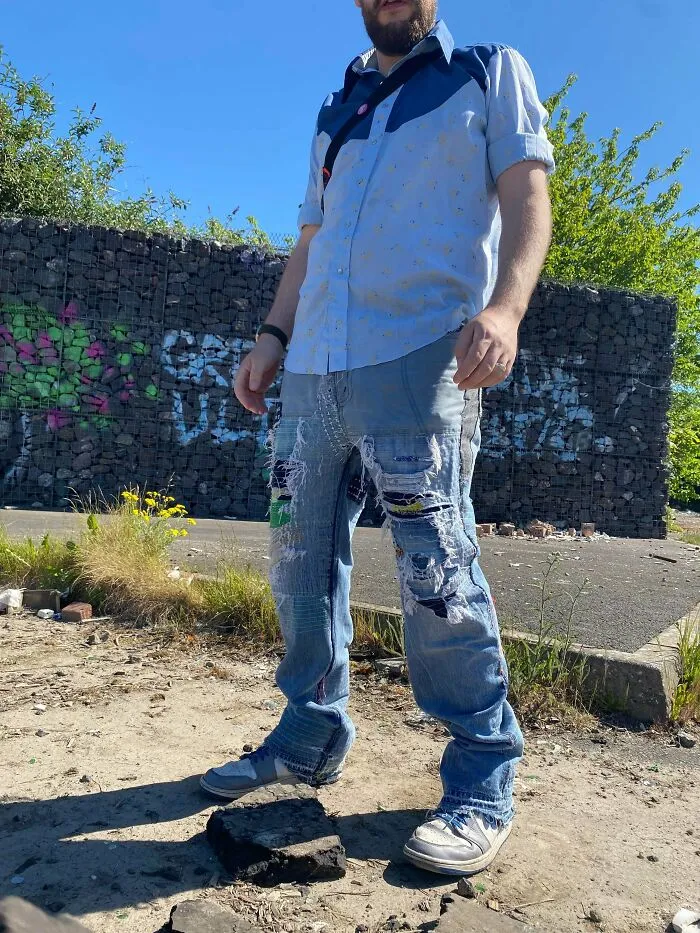 A person wearing custom mended denim jeans, proving creativity can save money through visible repair art.