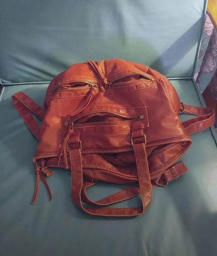 A brown leather bag creating a face optical illusion on a chair
