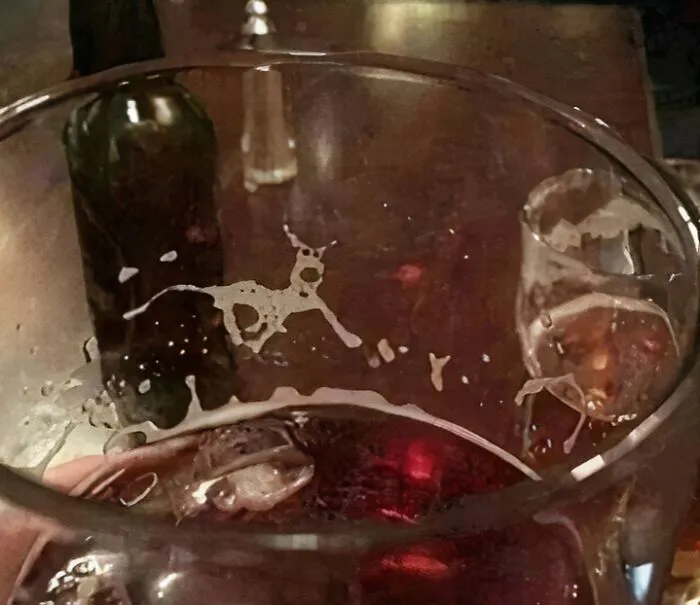 Optical illusion photo of beer foam in a glass forming the shape of a running deer.