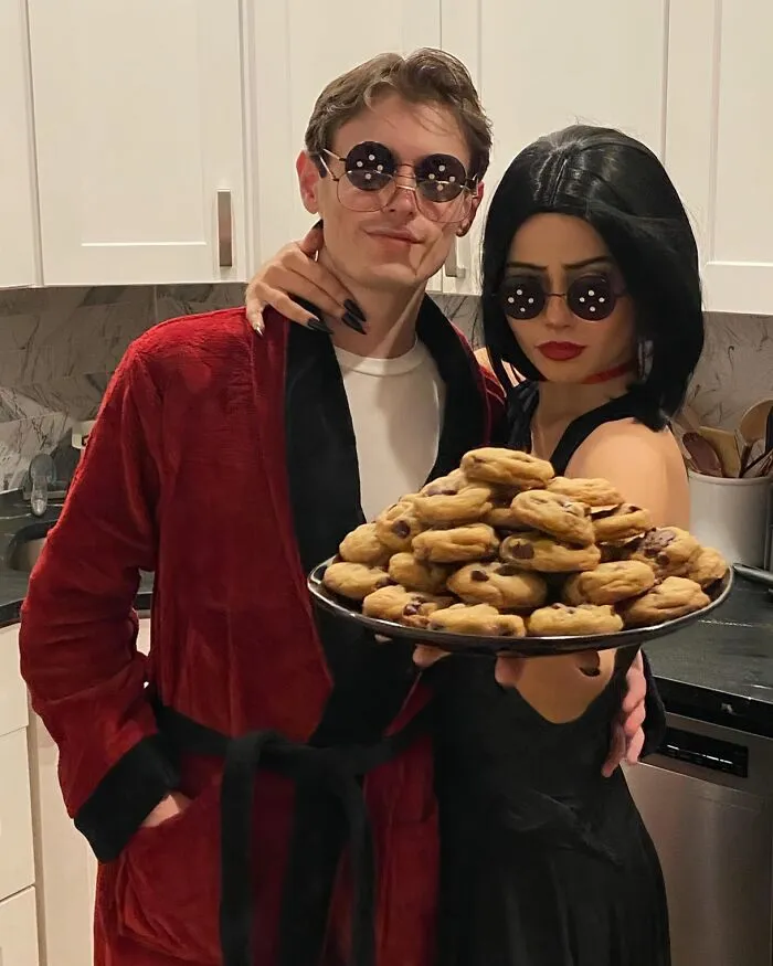 Couple in button-eye glasses holding cookies for funny Halloween couples costumes.