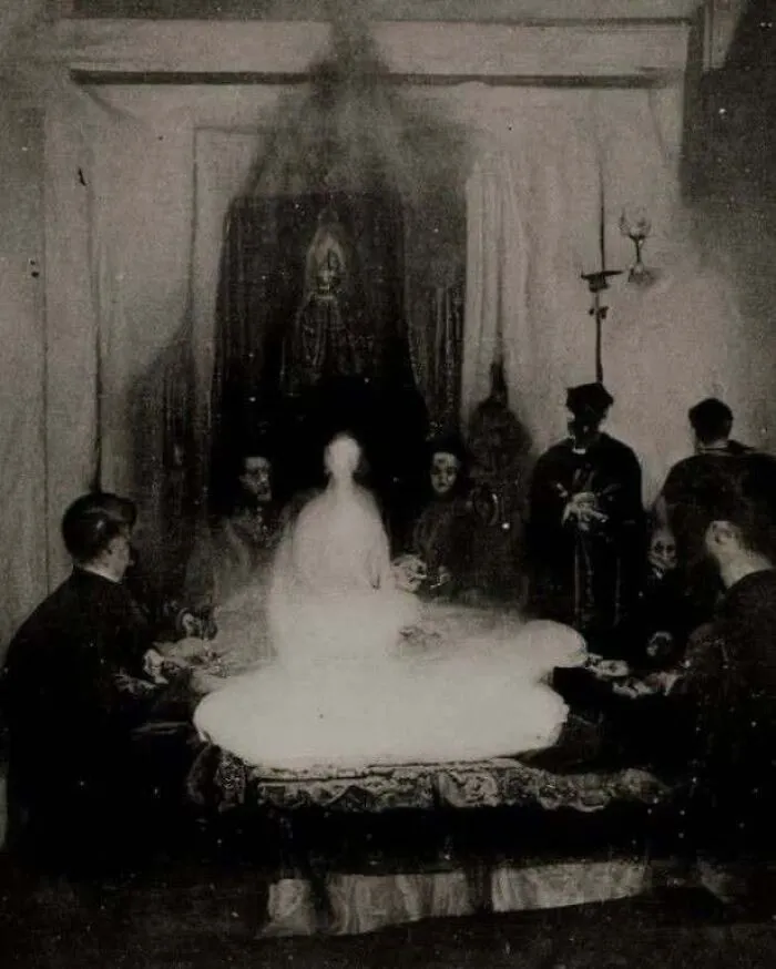 An eerie dark seance gathering with a glowing figure, captured in a eerie horror movie style photo.