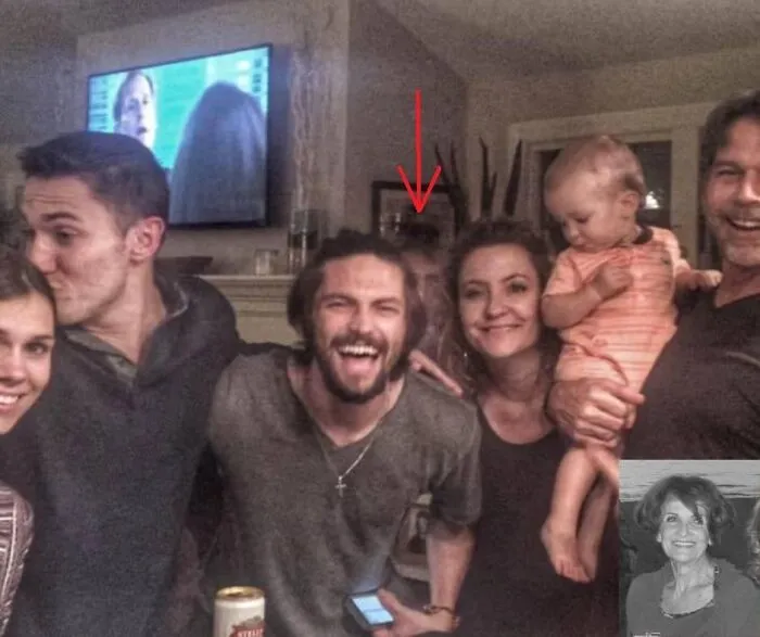 Spooky real-life photo of a family gathering with a eerie face lurking behind like a horror movie