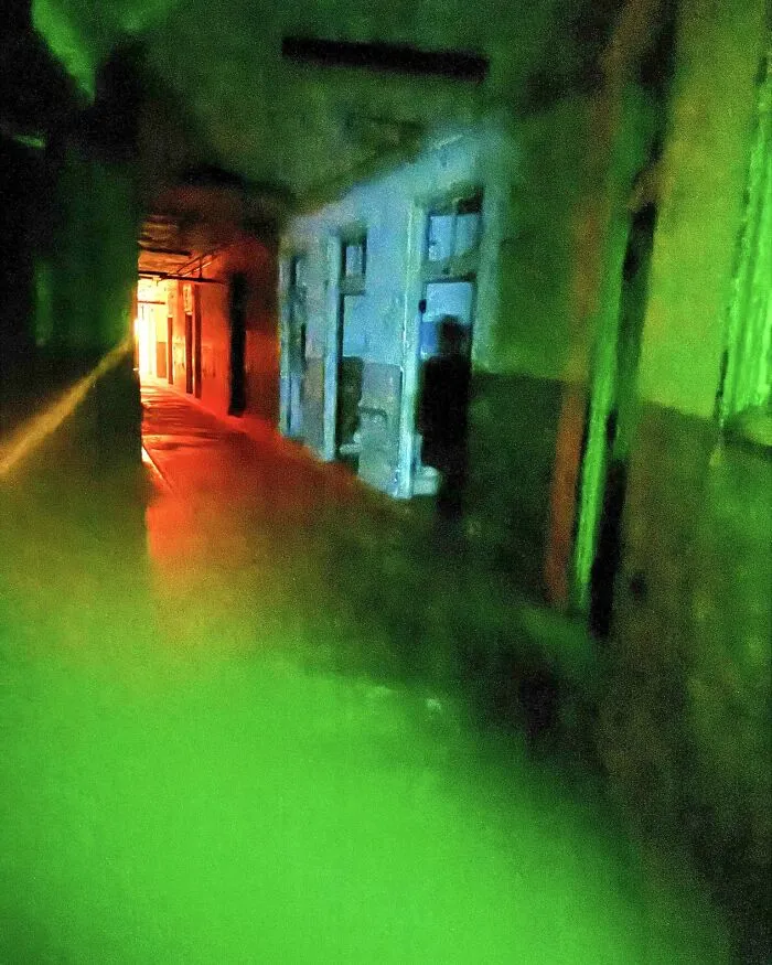 Eerie green light illuminating an abandoned hallway in a real-life horror movie setting.