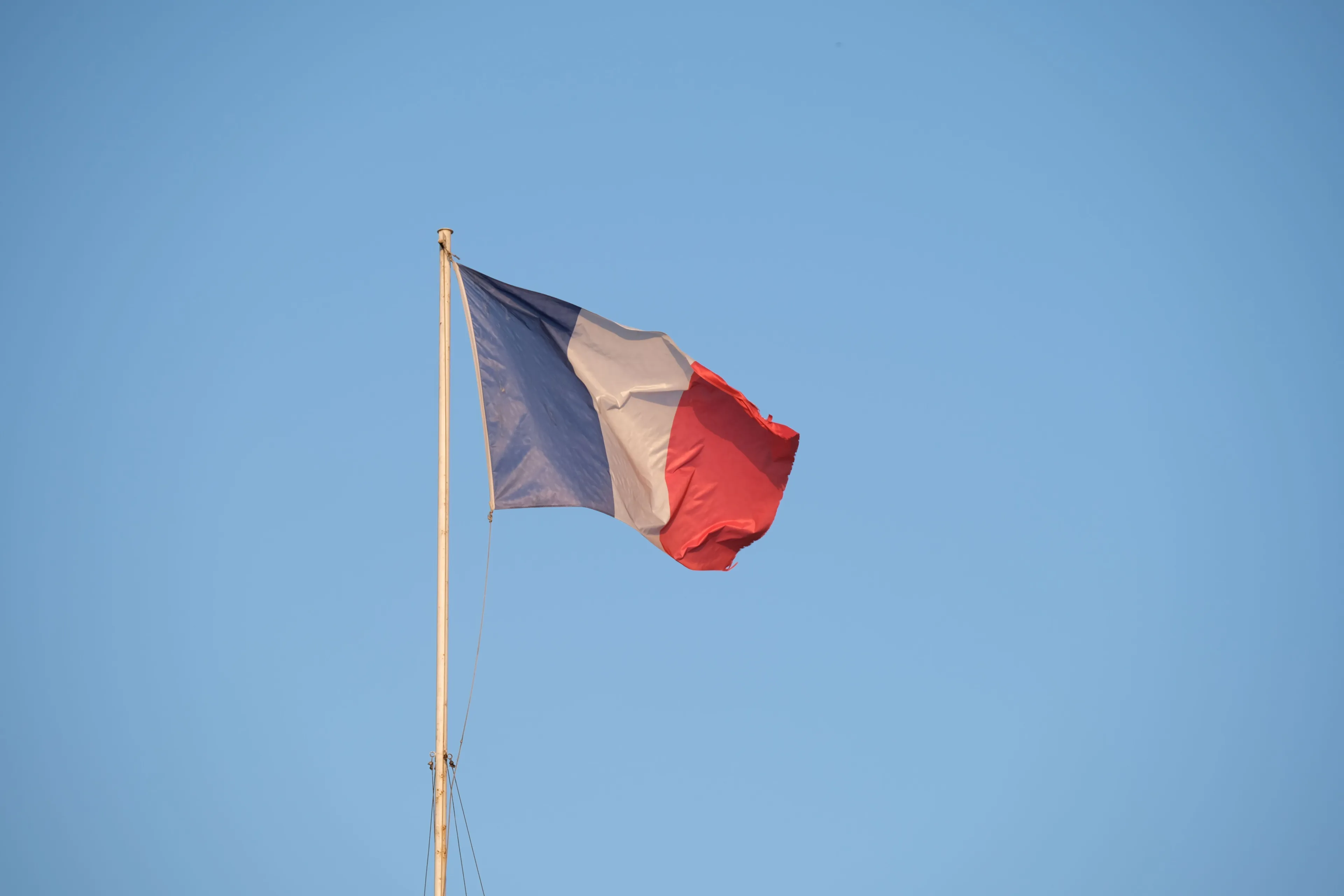 French flag flying in the sky for a general knowledge quiz question about the capital of France.