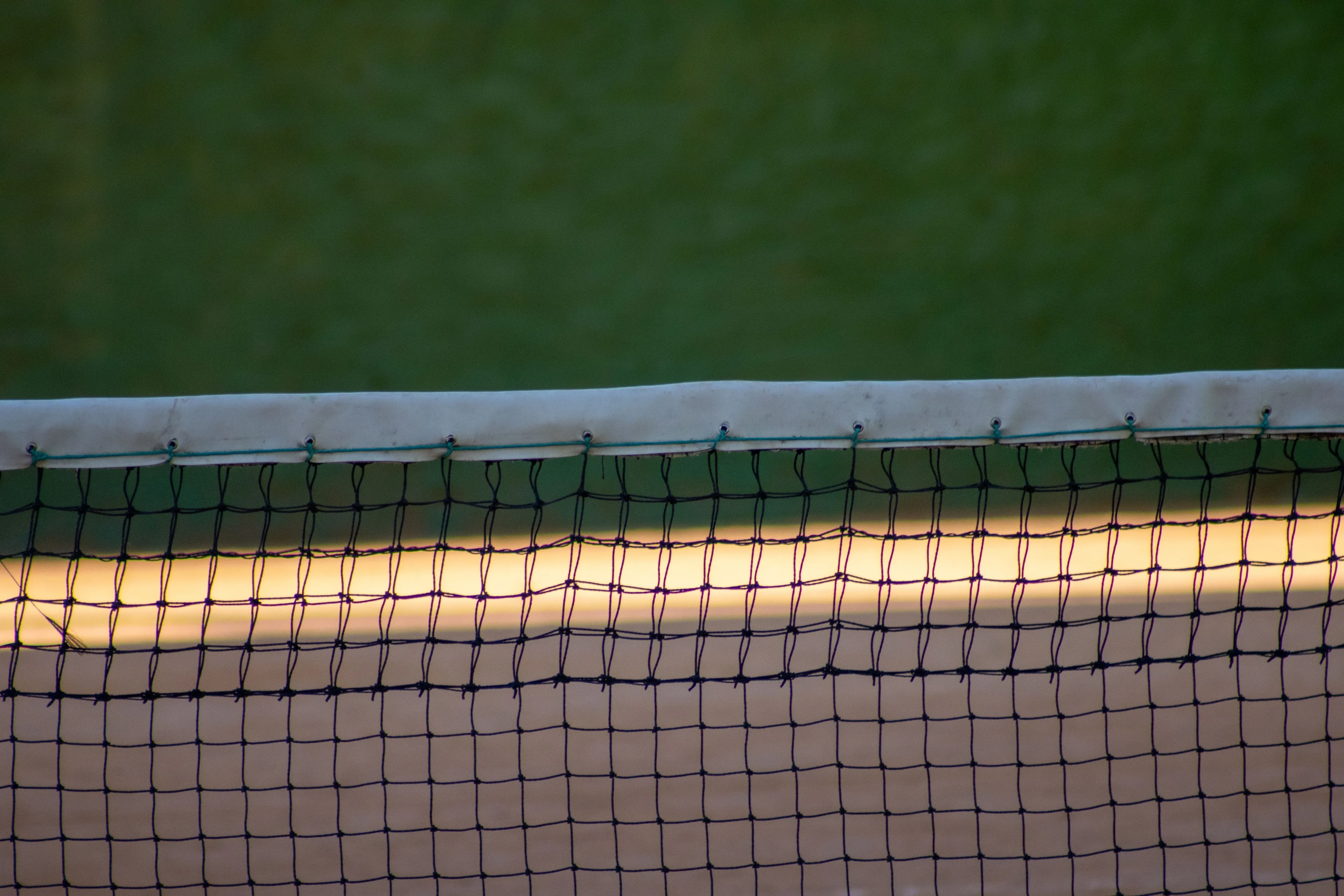 Close-up view of a tennis net stretching across a tennis court