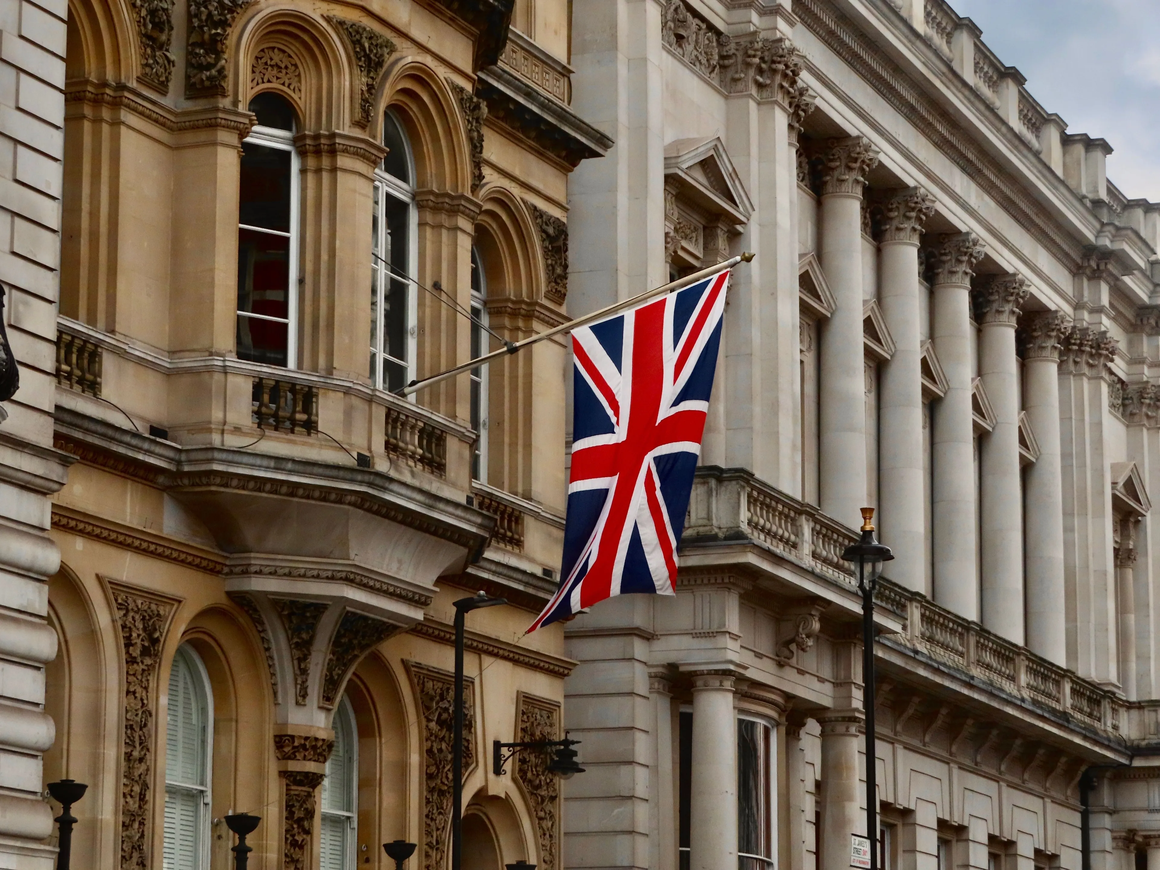 The Union Jack flag hanging outside a grand building in London, United Kingdom.