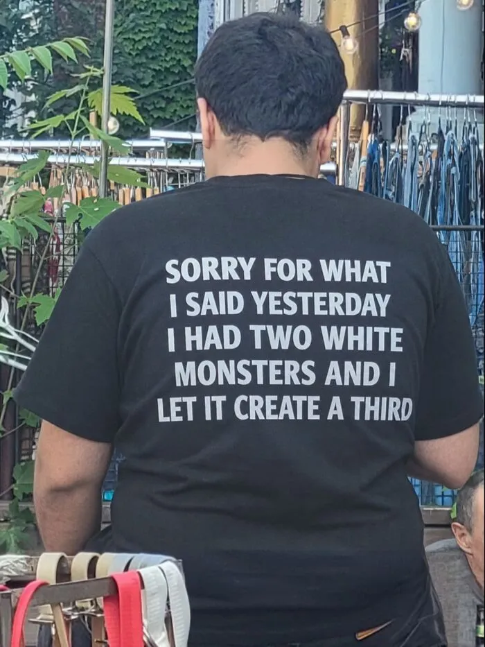Back of a black hilarious t-shirt featuring unexpected text about drinking White Monster energy drinks.