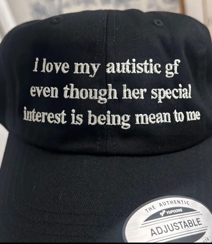 Black cap with unexpected humorous embroidered text about loving an autistic girlfriend.