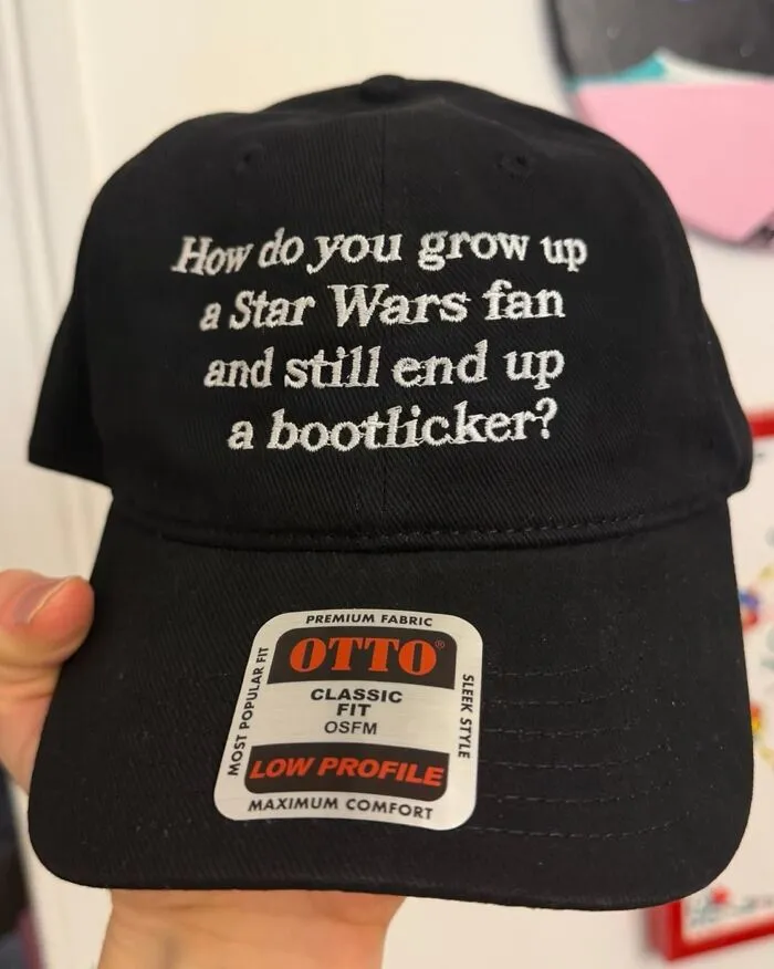 Black hat featuring unexpected embroidered text asking about Star Wars fans.