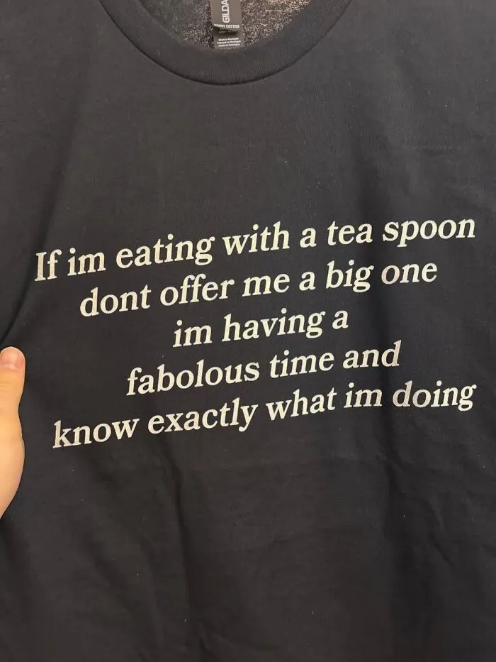 A black hilarious t-shirt with unexpected funny text about eating with a teaspoon.
