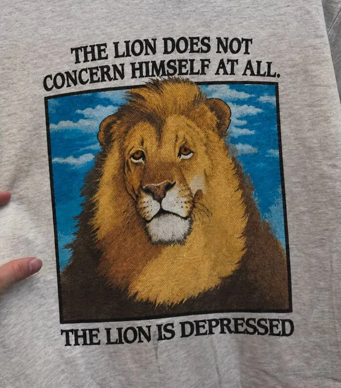 A hilarious t-shirt featuring a sad lion and text reading the lion is depressed.