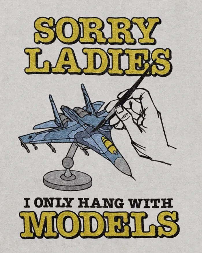 A hilarious t-shirt graphic showing a hand painting a toy jet plane with text about hanging with models.