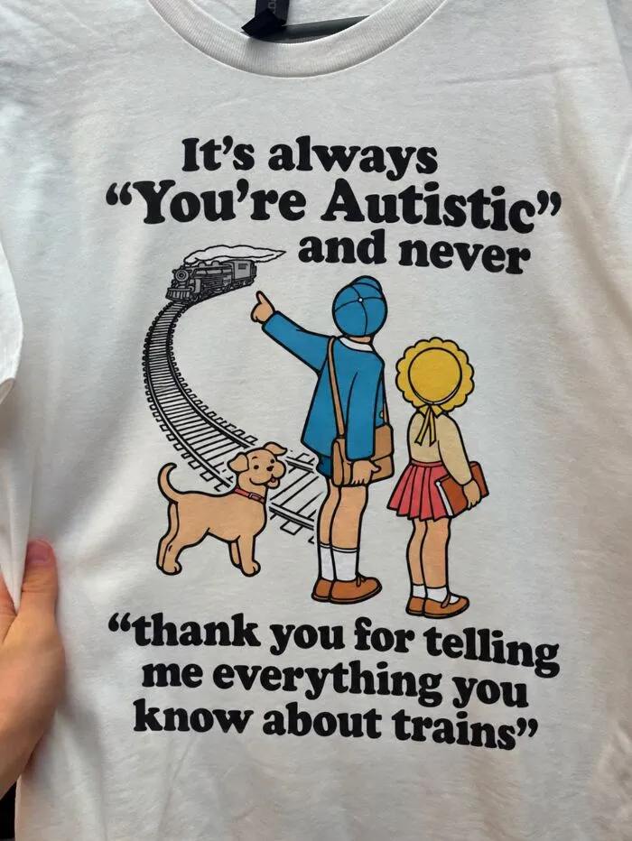 A white hilarious t-shirt with a vintage illustration of children watching a train and a funny text about trains.