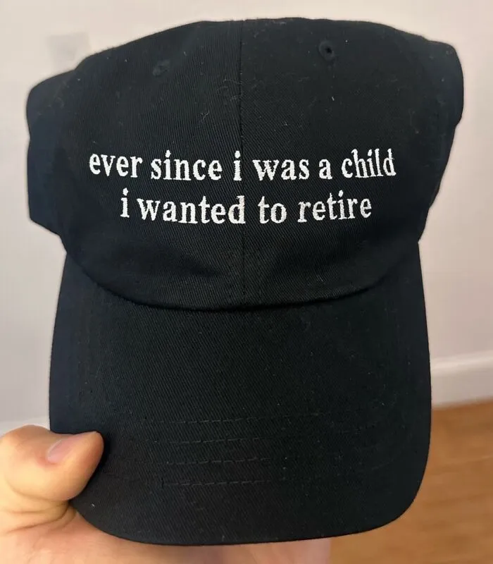 Black baseball cap displaying funny text about wanting to retire since childhood.