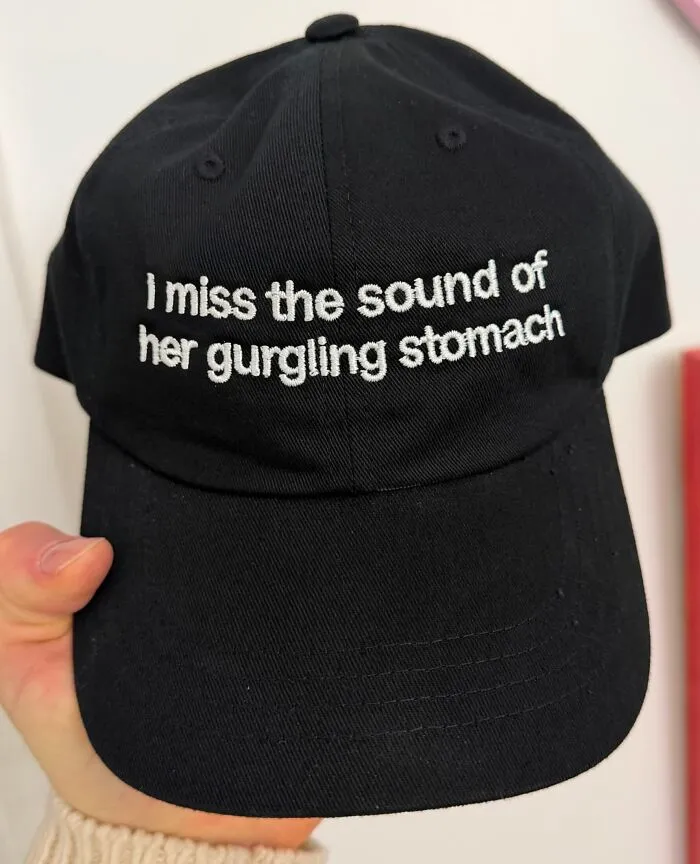 Black hat with funny text saying I miss the sound of her gurgling stomach.