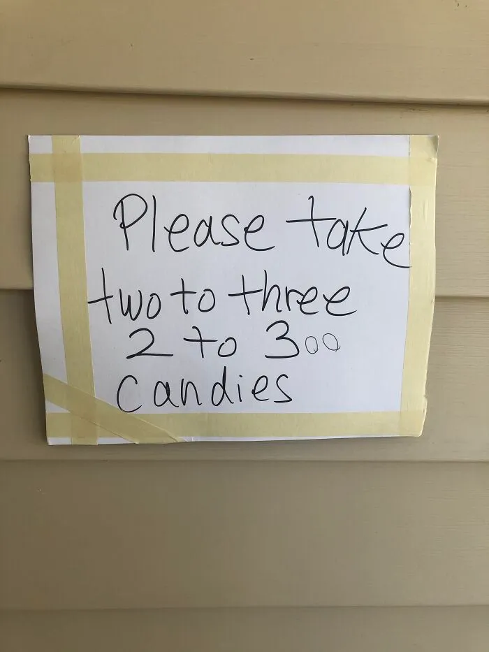 Funny handwritten Halloween sign saying to take 2 to 300 candies.