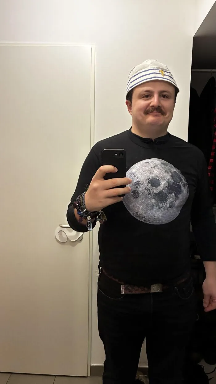 A man taking a mirror selfie wearing a sailor hat and a moon shirt for Halloween photos funny idea
