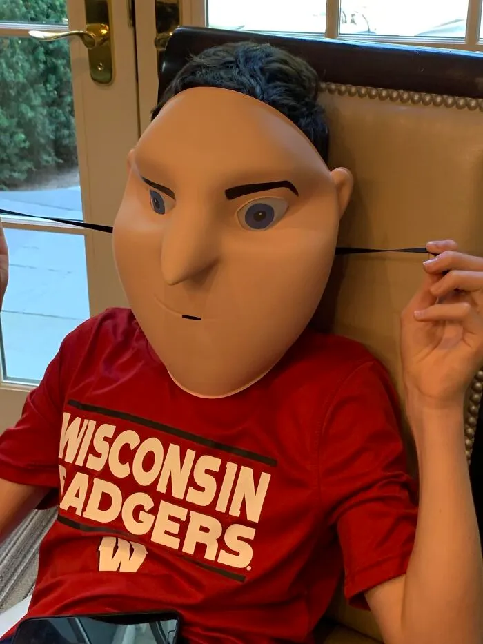 Person wearing a strange plastic Gru mask that fails to look like the character for Halloween