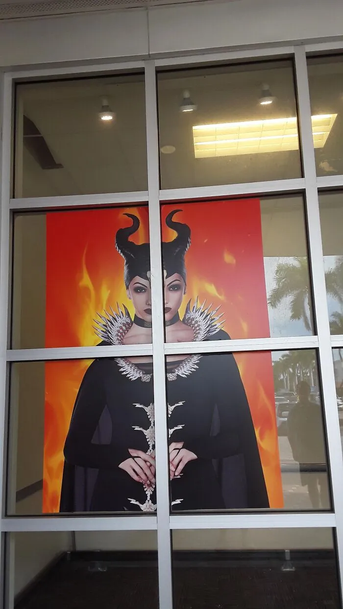 Poster of Maleficent cut awkwardly across double glass doors as a Halloween fail