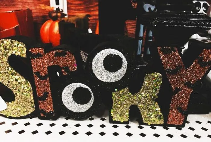 Glittery Halloween sign spelling out SPOOKY with googly eyes replacing the letter O