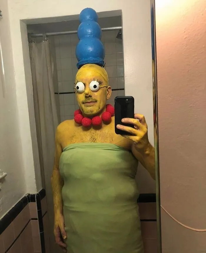 Funny Halloween photo of a person wearing a homemade Marge Simpson costume in a bathroom.