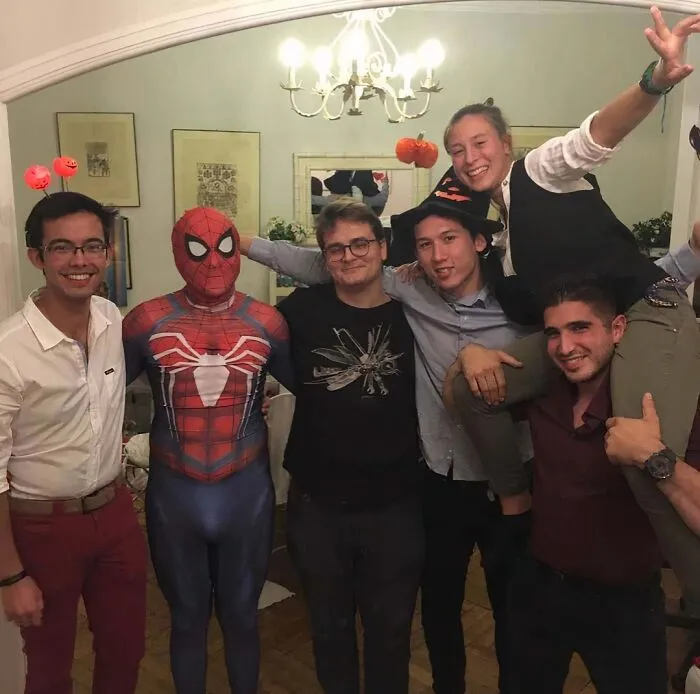 Funny Halloween group photo featuring a man in a Spider-Man suit.