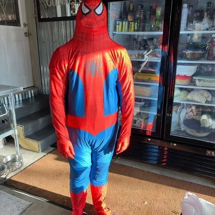 Funny Halloween photo of a person wearing an ill-fitting full-body Spider-Man suit.