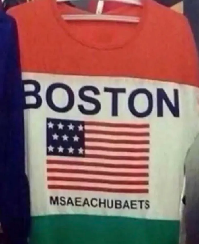 Red and white sweatshirt with spelling fails printed as MSAEACHUBAETS under the word Boston and flag